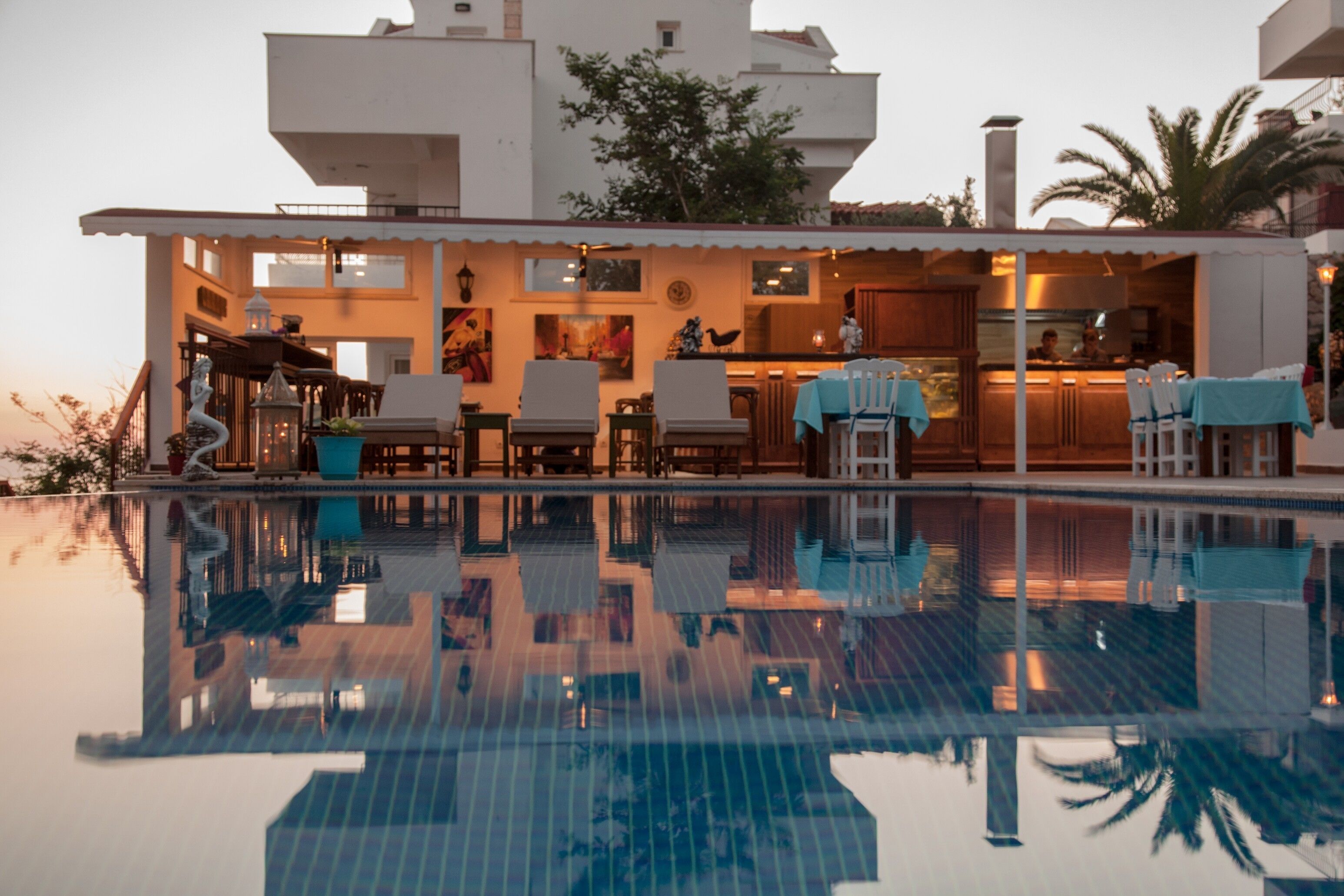A modern pool area with clear reflections, a bar, and outdoor seating.