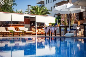 A poolside area with lounge chairs, a bar, and umbrellas. - Sunset Villa Hotel (Kas)