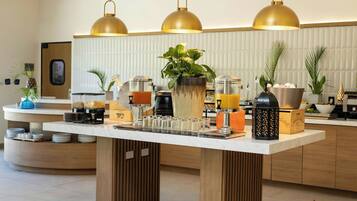 A breakfast bar with coffee machines, a fruit bowl, and a variety of breakfast items.