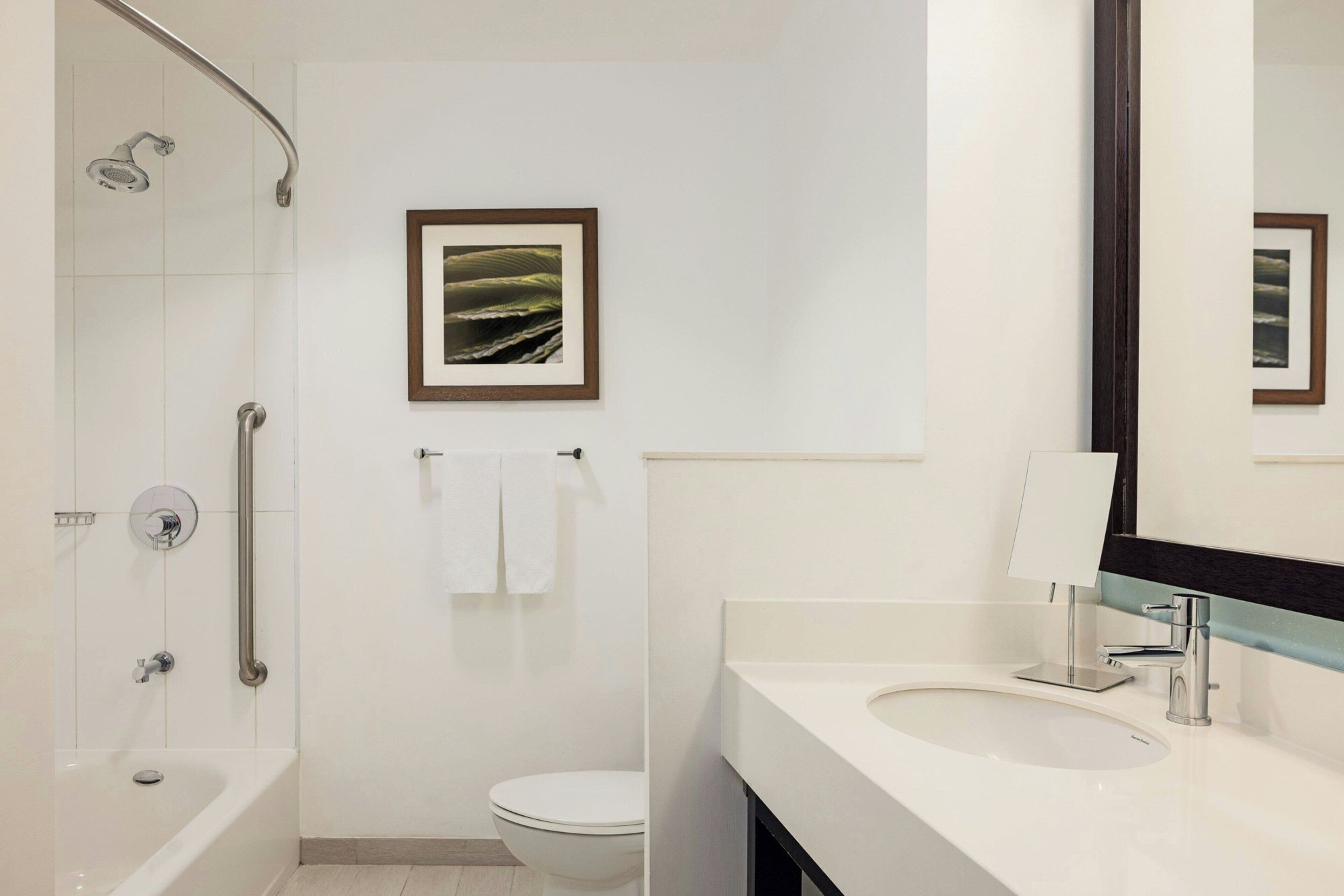 Une salle de bain moderne équipée d’une baignoire, de toilettes et d’un lavabo.