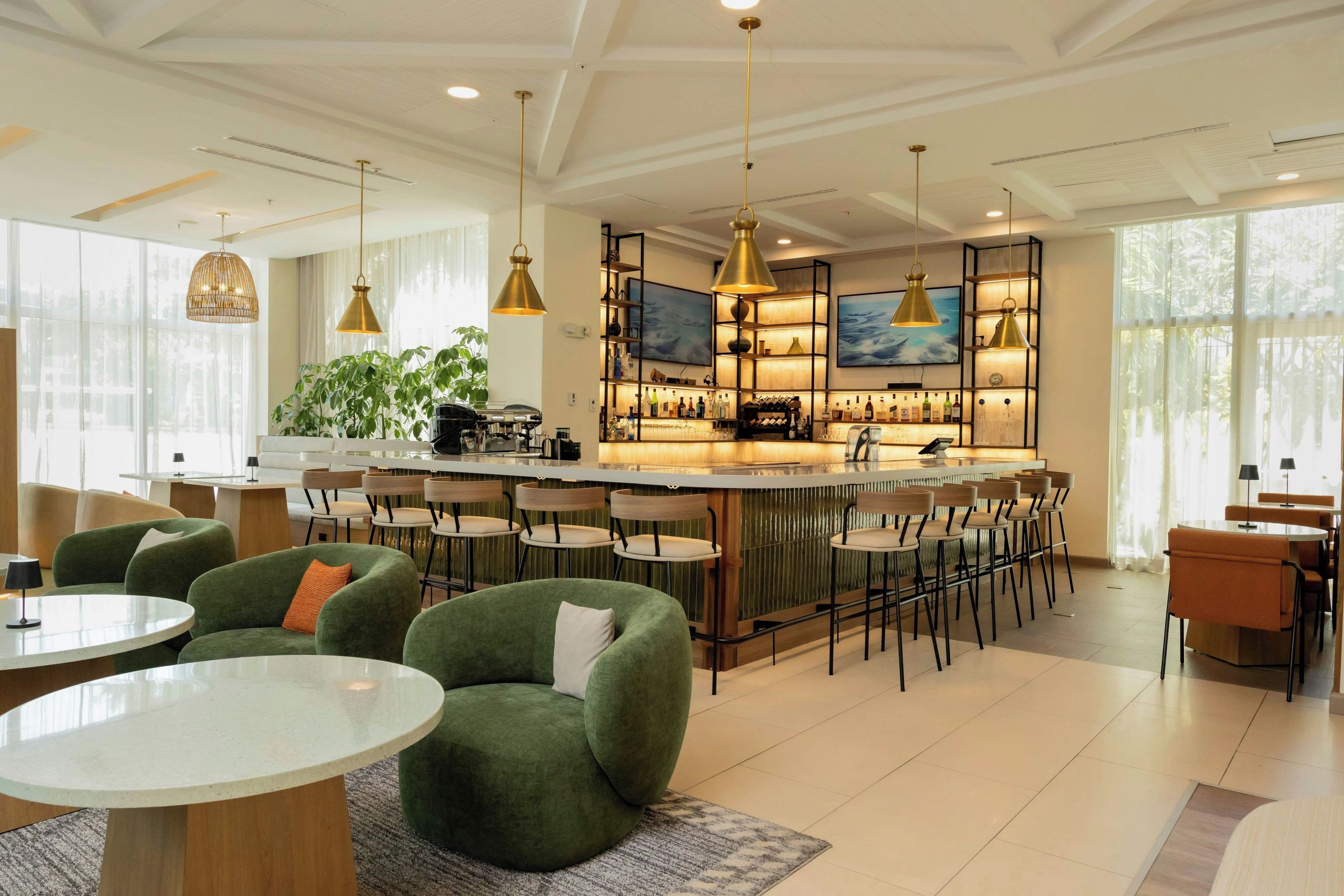 A modern bar area with seating, a coffee machine, and a television.