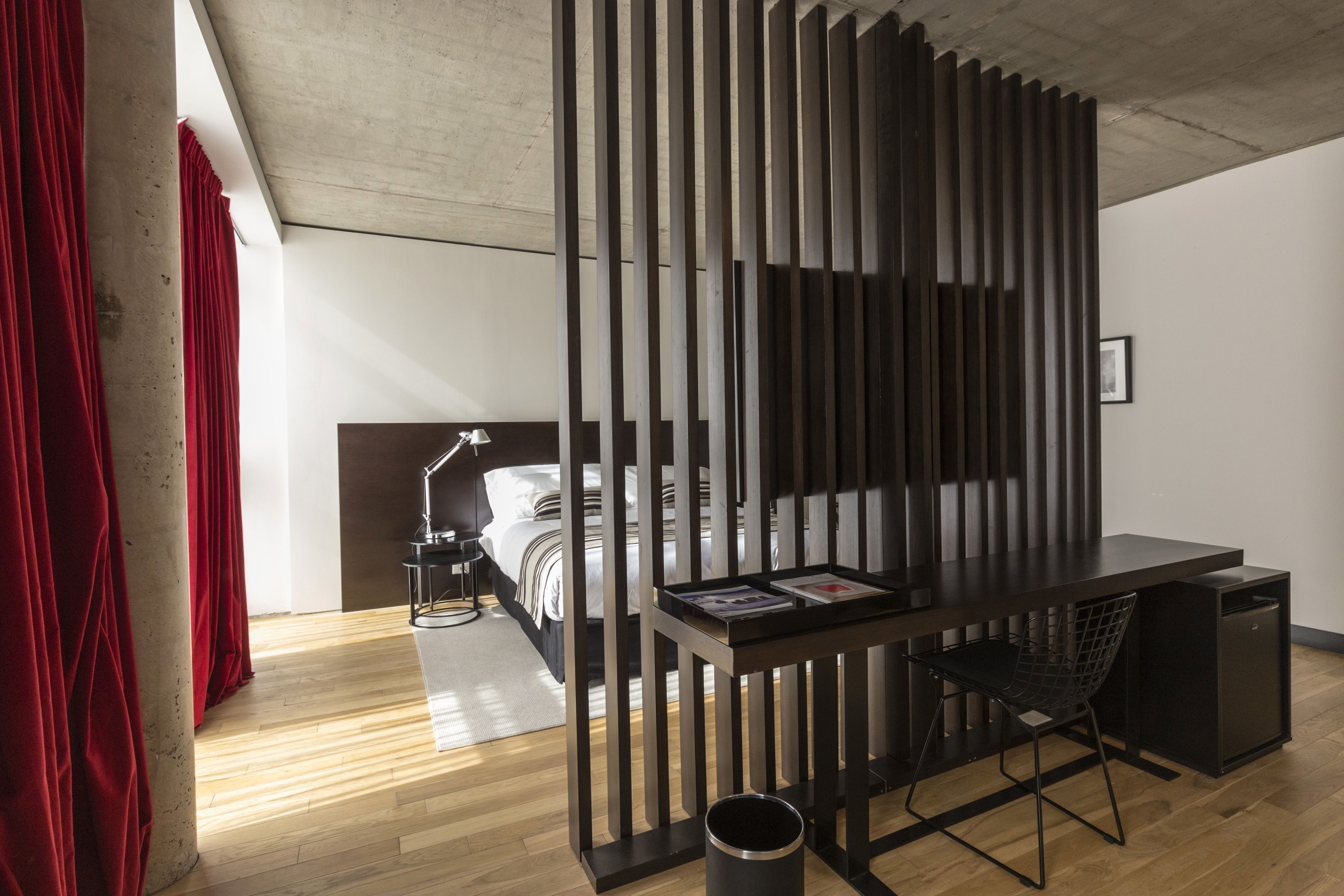 Un dormitorio moderno con un escritorio de madera, una cama y una mesita de noche.