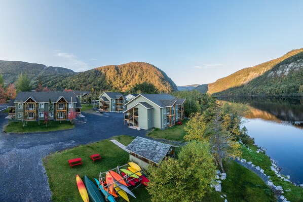A lodge with multiple buildings, a dock, and canoes. - Marble Inn Resort (Steady Brook)