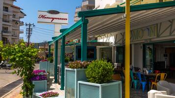 A hotel with outdoor seating and a sign that reads "Honeymoon."