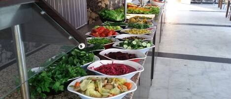 Un bufé con diversas verduras y ensaladas.