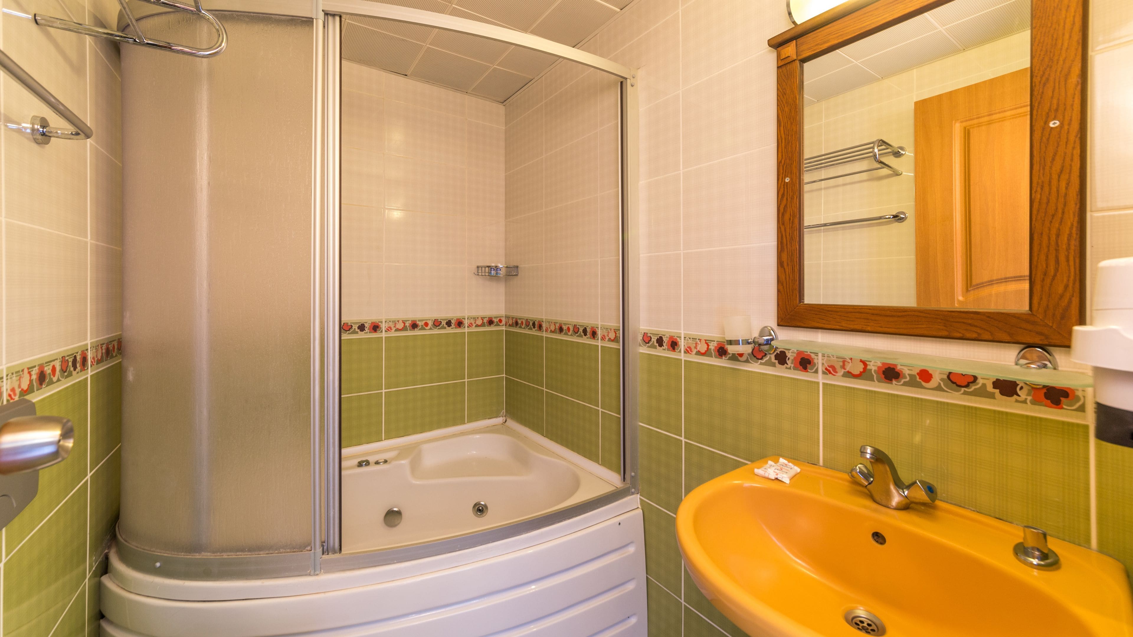 A bathroom with a shower enclosure, a bathtub, and a sink.