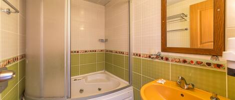 A bathroom with a shower enclosure, a bathtub, and a sink.