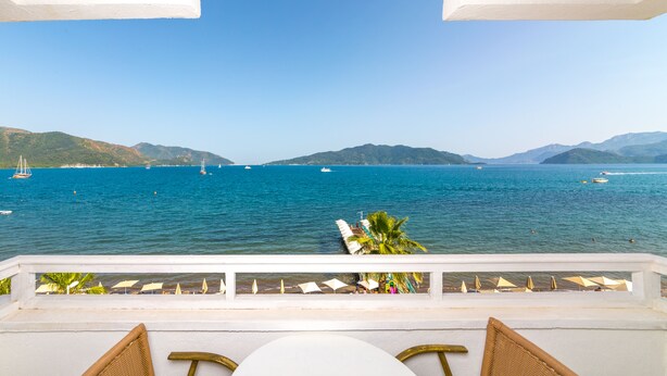 A balcony with a view of the sea, white railings, and a row of white umbrellas. - Honeymoon Hotel (Marmaris)