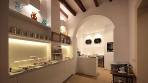 Una cocina moderna con barra desayunadora, armarios blancos y objetos decorativos en estantes.