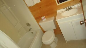 Un baño con bañera, inodoro y lavamanos.