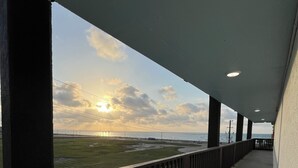 A covered walkway with a view of the sea and sunset. - Hotel De Ville (Corpus Christi)