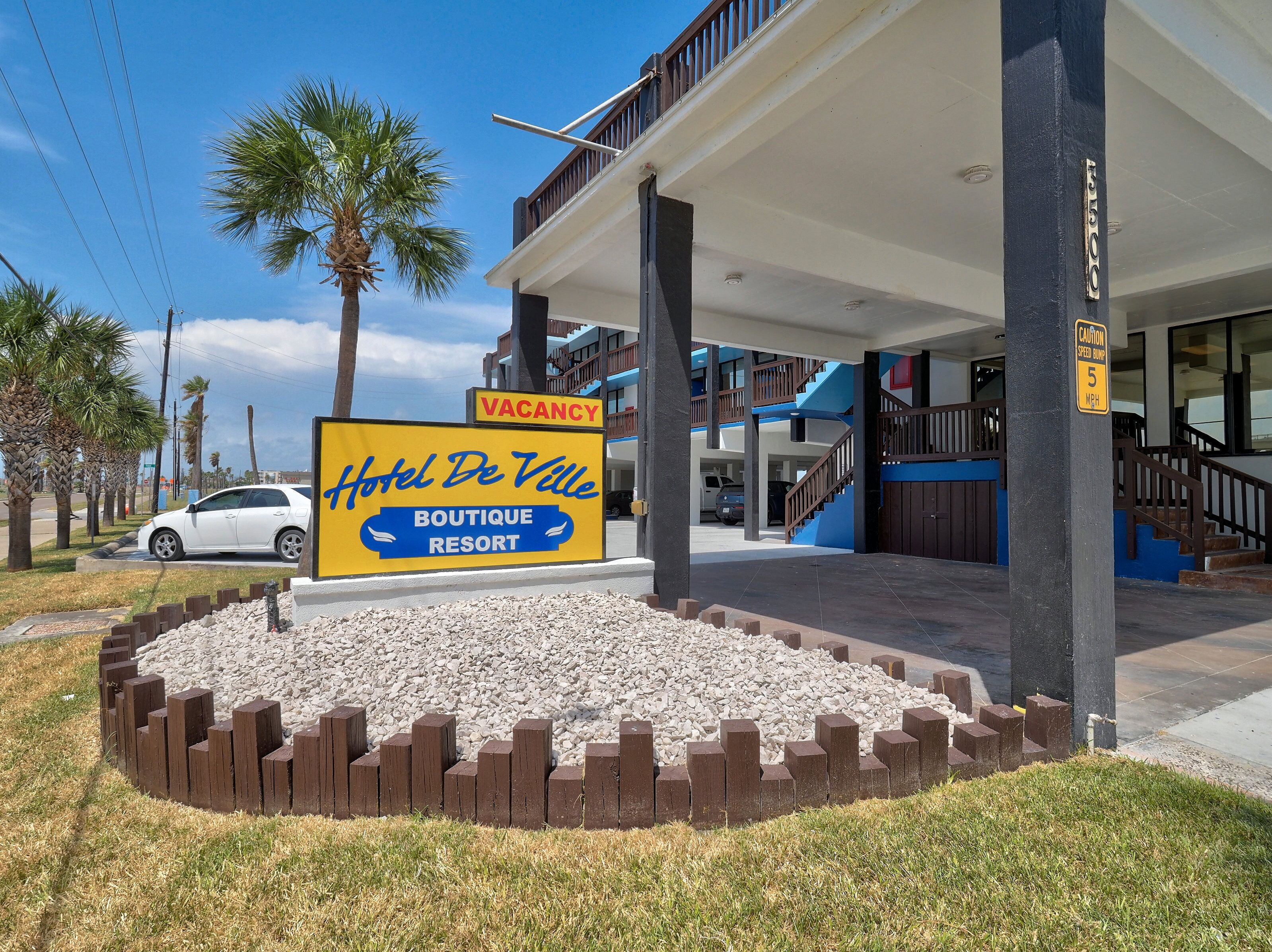 A hotel sign with a vacancy notice, a covered entrance, and a staircase leading to a balcony.