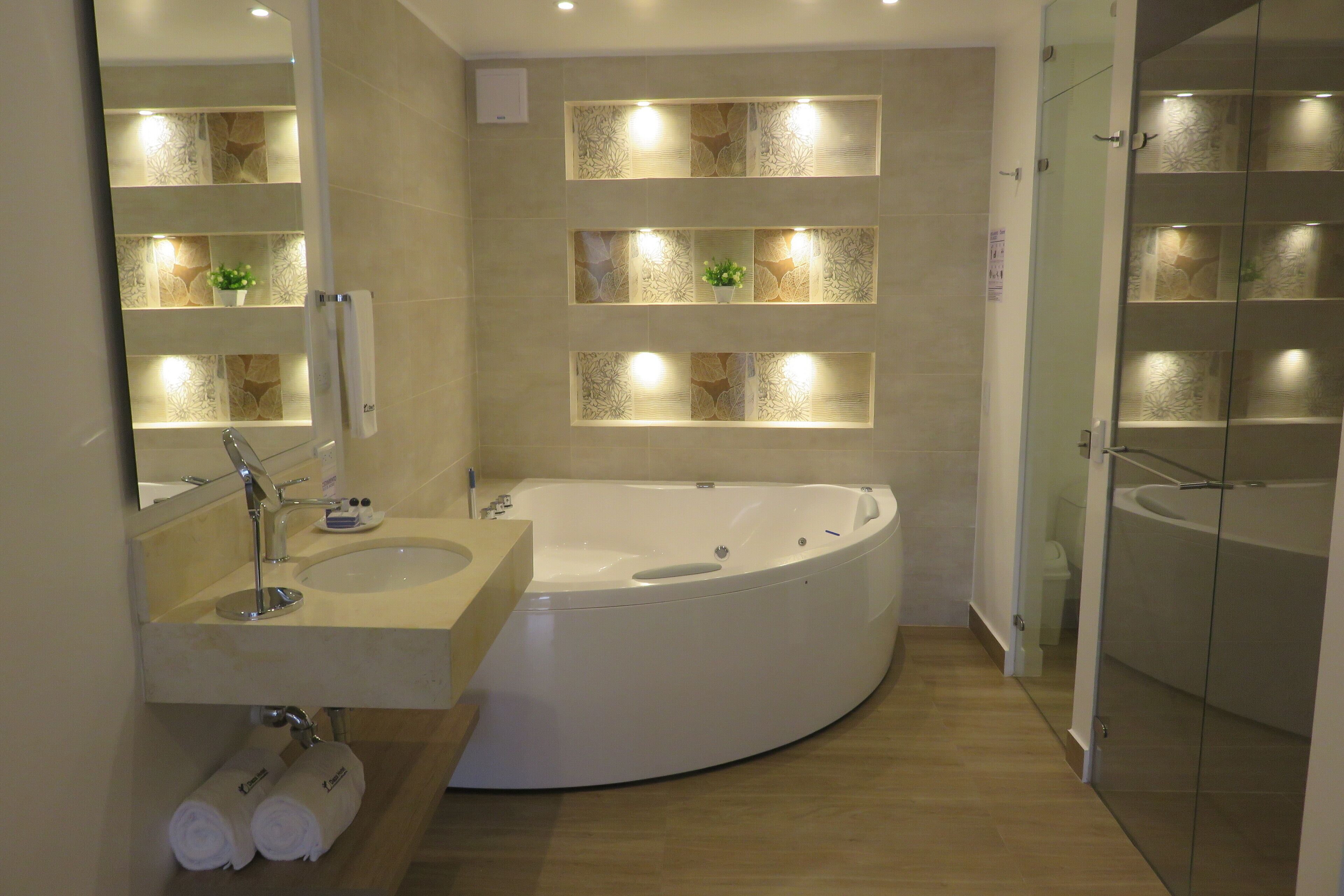 Un baño moderno con una bañera independiente, un lavabo con espejo y una zona de ducha con mampara de vidrio.