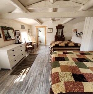 Quarto com cama de madeira, cômoda, cadeira e espelho.
