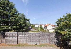 Een woonstraat met huizen, een houten hek en bomen.