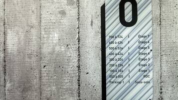 A parking sign with numbered parking spaces and corresponding building stages.