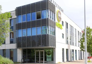 A modern hotel building with a prominent 'B&B' sign, large windows, and a welcoming entrance.