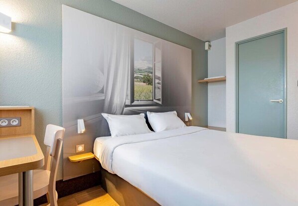A hotel room with a bed, bedside table, chair, and a window with curtains. - B&B HOTEL Boulogne-sur-Mer Saint-Martin (Saint-Martin-Boulogne)