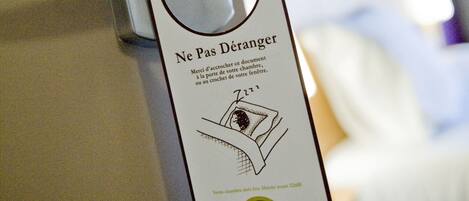 A hotel room door with a keycard reader and a keycard with a message in French.