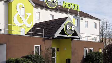 Ein Bed & Breakfast Hotel mit einer markanten, gelben Fassade und einem gut sichtbaren 'B&B' Schild.