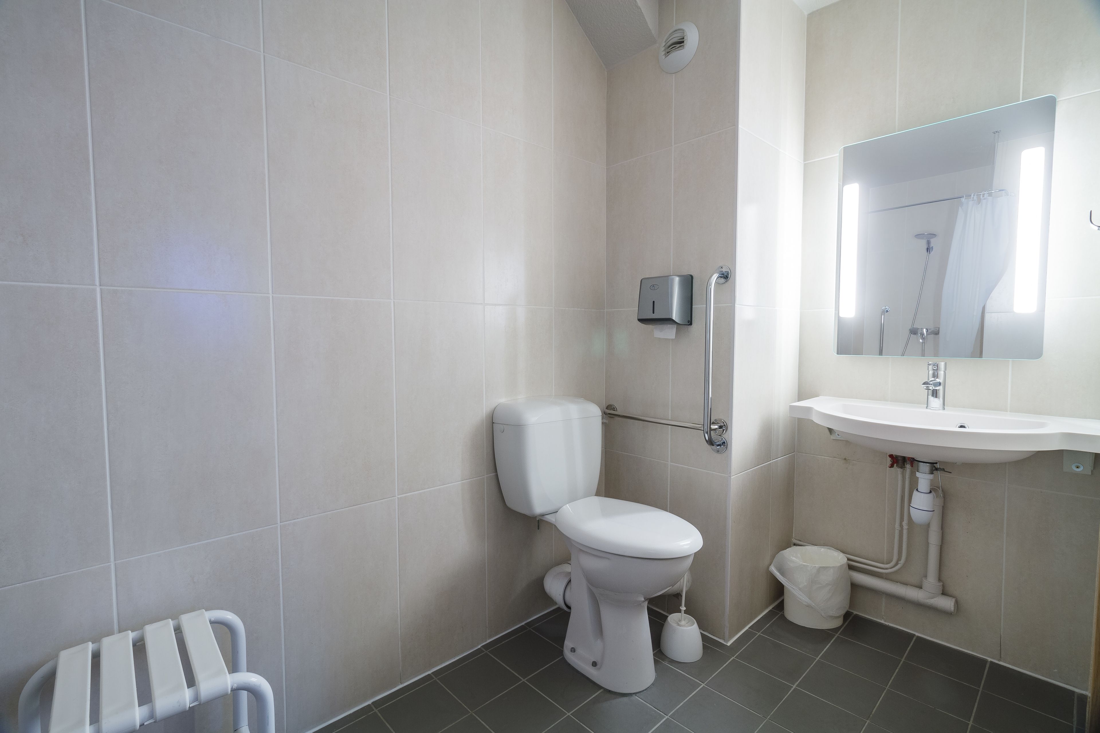A modern bathroom with a toilet, sink, and shower.