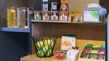Une présentation de divers produits alimentaires, notamment des pots de miel, des pots de confiture et une boîte de mouchoirs.