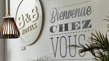 Una pared con un letrero de 'B&B' y un cartel de bienvenida que dice 'Bienvenue Chez Vous'.