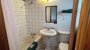 A bathroom with a bathtub, a sink, and a toilet.