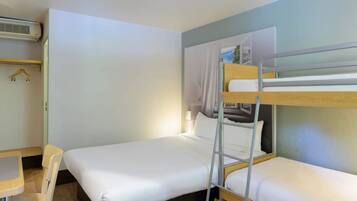 Une chambre avec un lit superposé, un lit simple, un bureau et une chaise.