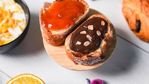 Two pastries on a wooden board, one with a red filling and the other with chocolate and nuts. - B&B HOTEL Châlons-en-Champagne (Chalons-en-Champagne)