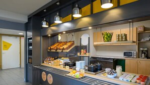 Een ontbijtbuffet met diverse etenswaren en keukenapparatuur.