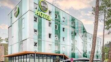 A B&B hotel with a modern design, large windows, and a visible entrance.