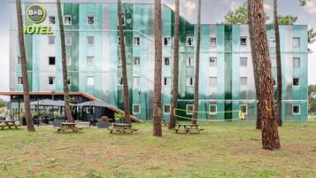 A B&B hotel with a modern design, outdoor seating, and a grassy area.