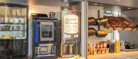 A breakfast counter with a coffee machine, a refrigerator, and baskets of bread.