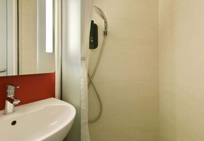 Een douche, handdoeken, zeep, toiletpapier