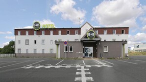 A B&B hotel with a modern design, featuring a central entrance and multiple parking spaces. - B&B HOTEL Le Mans Nord 1 (Saint-Saturnin)