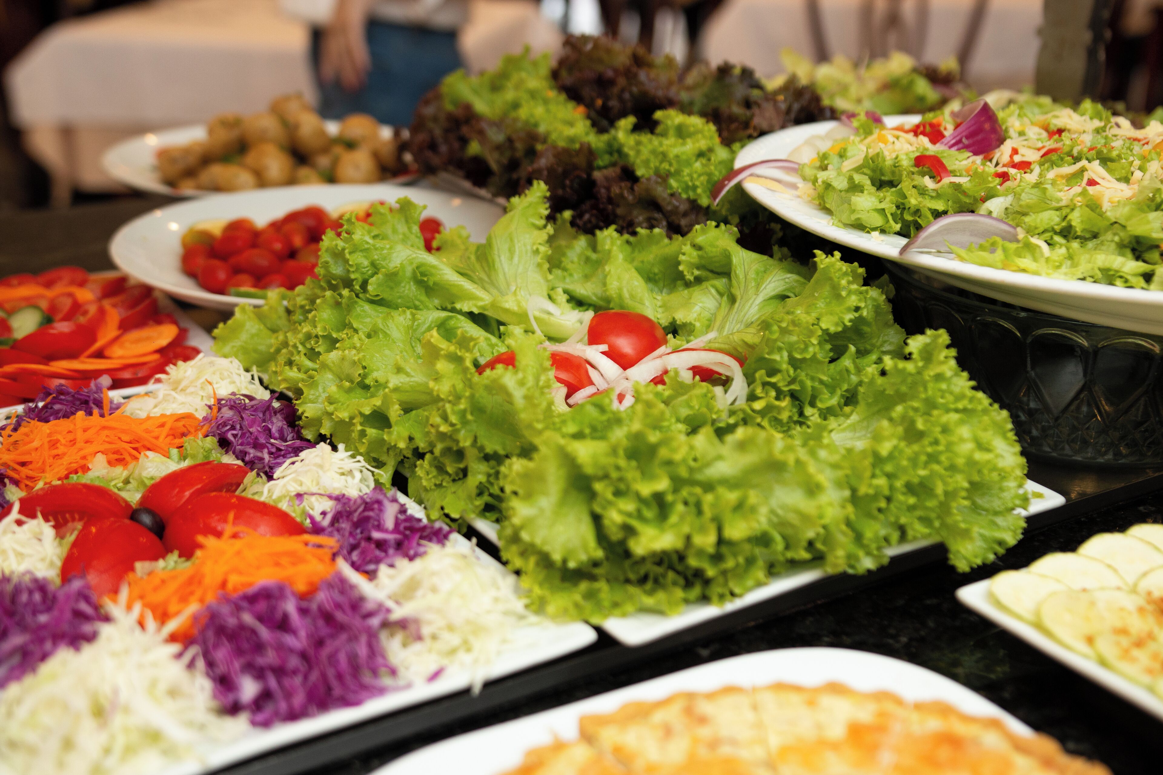 Un bufé con ensaladas y verduras variadas.