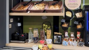 A breakfast buffet with various pastries, bread, and condiments. - B&B HOTEL Saint-Michel-sur-Orge (Saint-Michel-sur-Orge)
