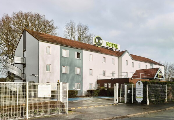 A B&B hotel with a white facade, multiple windows, and a sign indicating its name. - B&B HOTEL Saint-Michel-sur-Orge (Saint-Michel-sur-Orge)