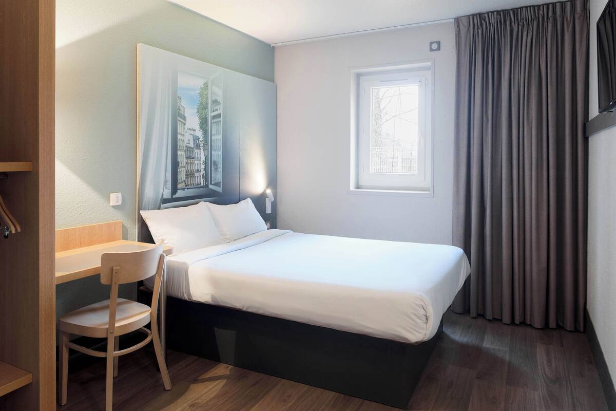 Ein Schlafzimmer mit einem Bett, einem Schreibtisch und einem Stuhl.