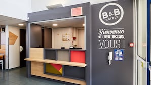 Un mostrador de recepción con un letrero que dice "B&B Hotels" y "Bienvenue Chez Vous".