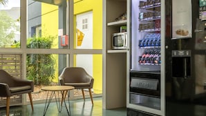 Un interior moderno con una máquina expendedora, un microondas y una zona de estar.
