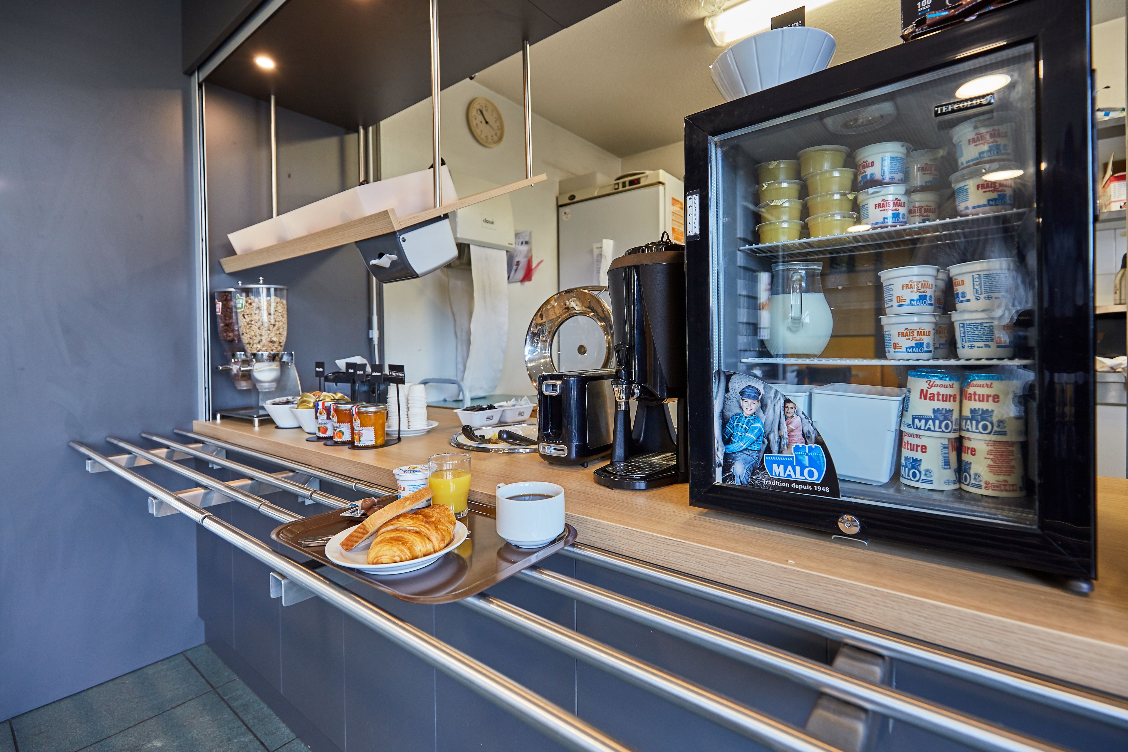 A breakfast bar with croissants, orange juice, and coffee.