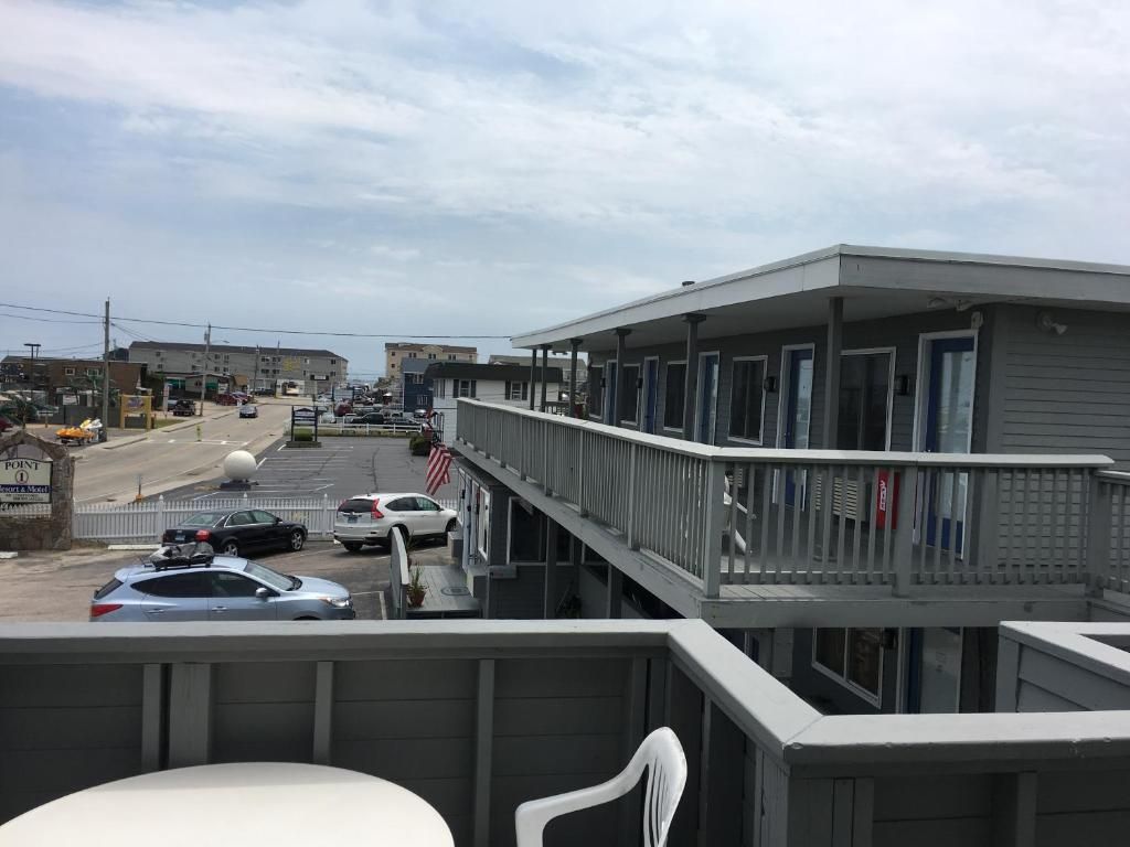 A motel with a covered outdoor area, a parking lot, and a street view.