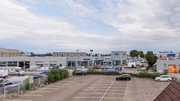 A parking lot with several cars and a large building with multiple storefronts.