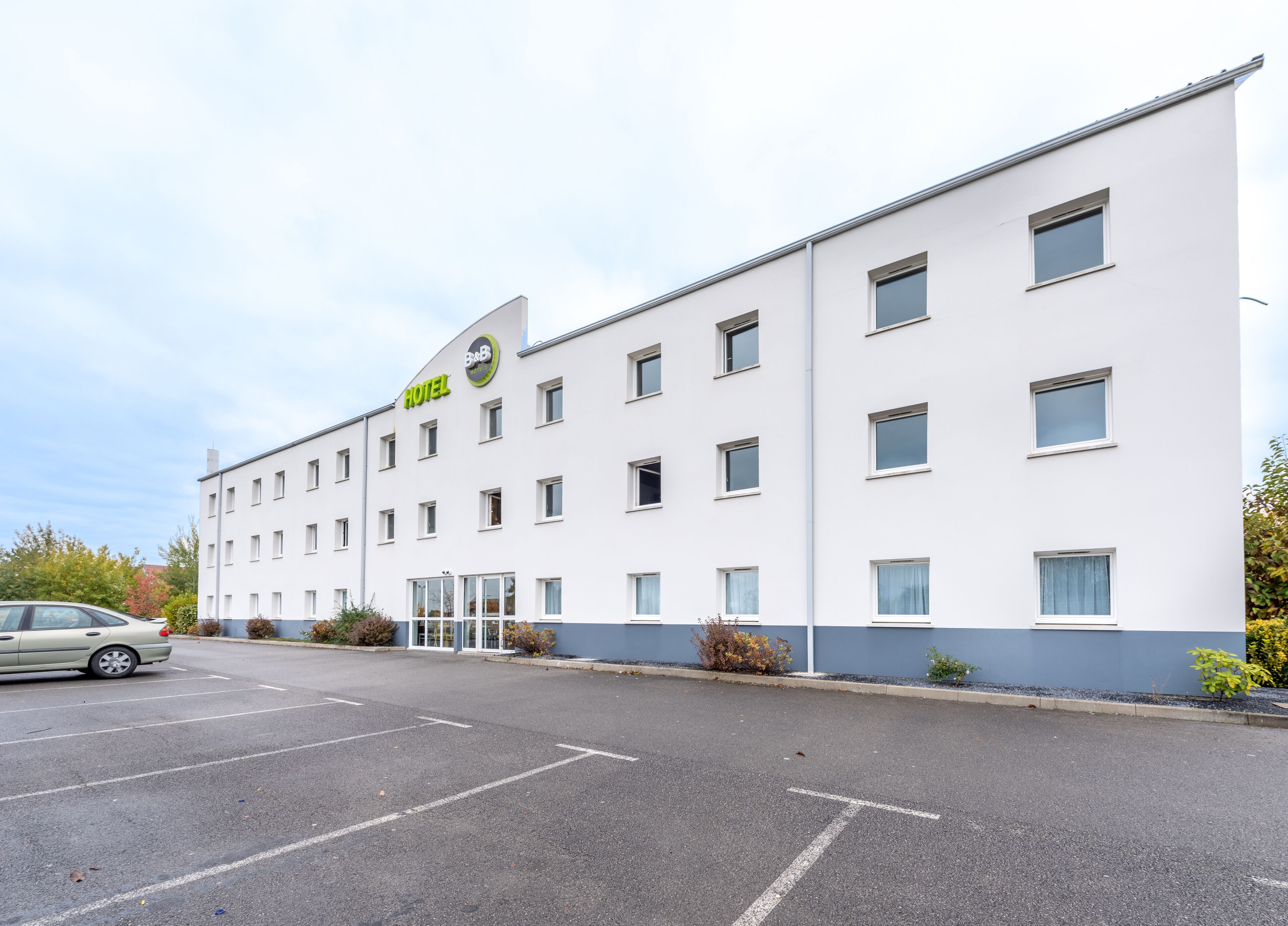 A modern hotel building with a white facade and multiple windows.