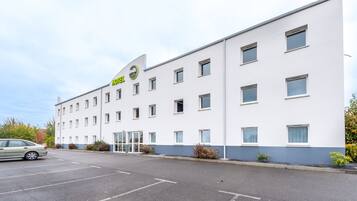 A modern hotel building with a white facade and multiple windows.