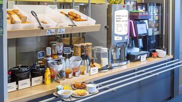 A breakfast buffet with various food items and a coffee machine.