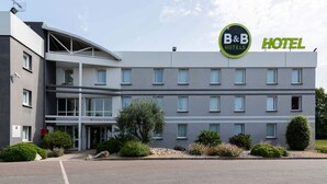 Een B&B hotel met een modern ontwerp, herkenbaar aan een plat dak, meerdere ramen en een uitnodigende entree.