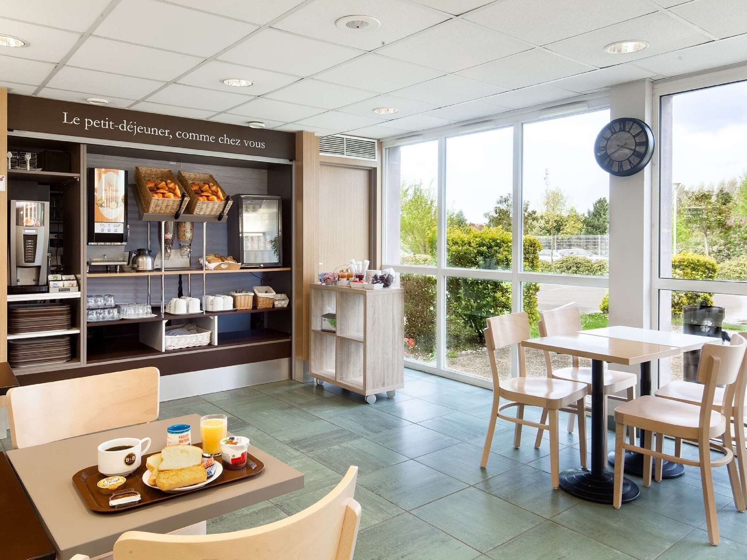 A modern cafe with a breakfast setup, including a tray with toast, juice, and yogurt.